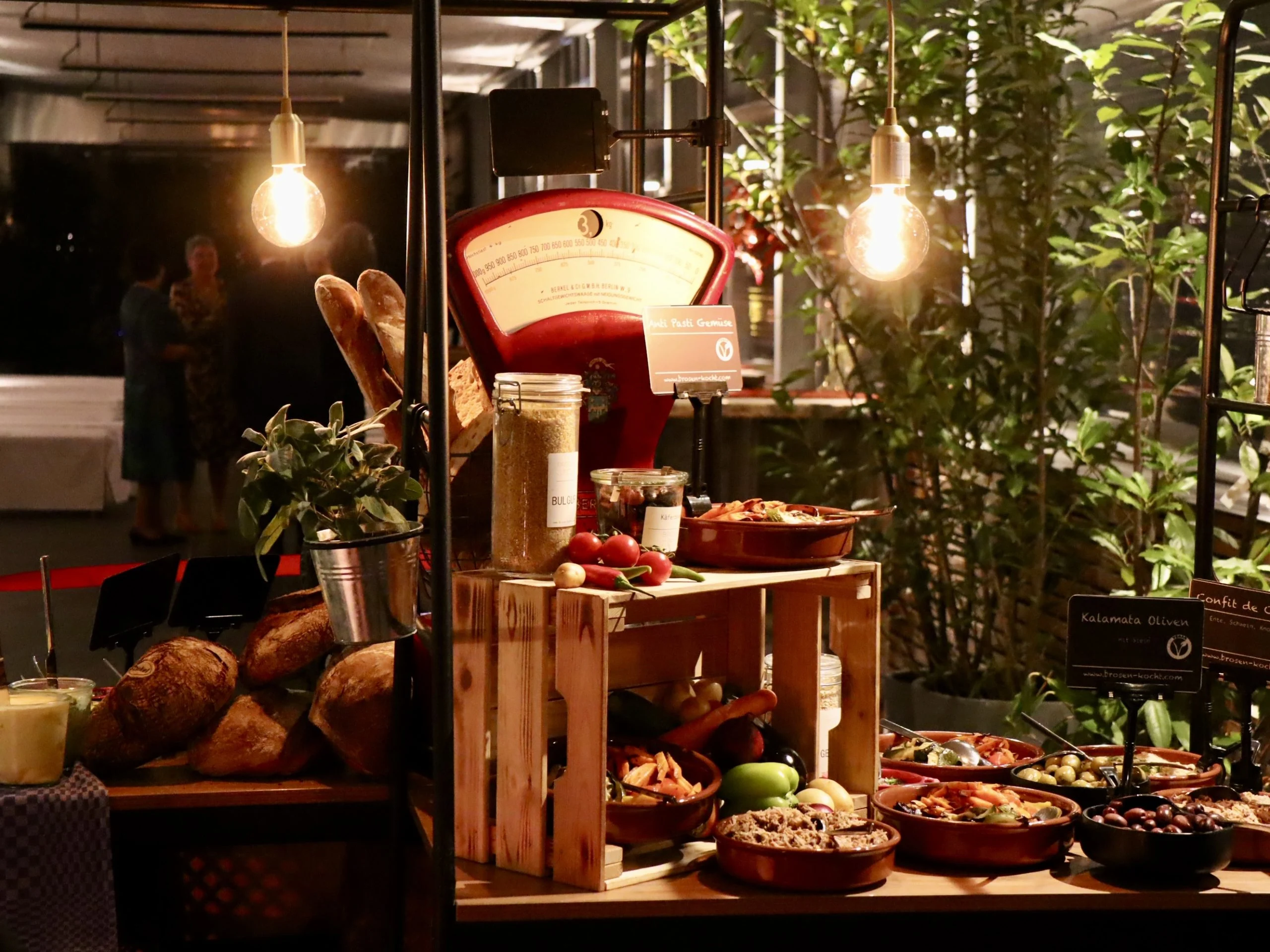 Übersicht eines Catering-Buffets mit Pflanzen und Lichterketten dekoriert