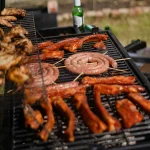 Grillstation mit Fleisch und Bratwürsten beim Sommerfest Catering