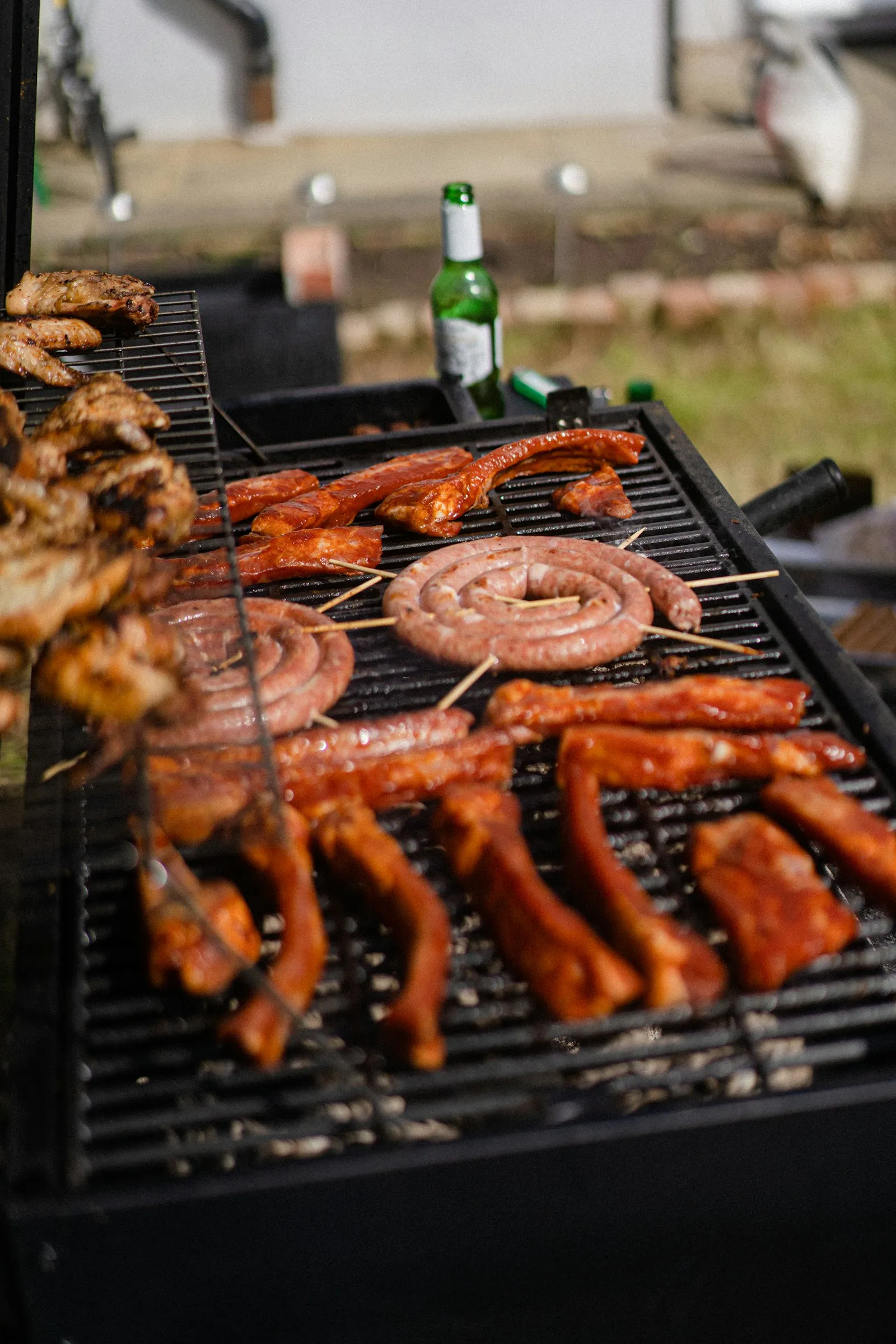 Grillstation mit Fleisch und Bratwürsten beim Sommerfest Catering